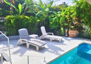 un par de sillas y una piscina en Adults Only Casa Cactus - Stylish Boho Studios with Garden and Pool Access, en Puerto Escondido