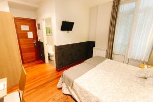 Łóżko lub łóżka w pokoju w obiekcie Hostal San Sebastian Centro