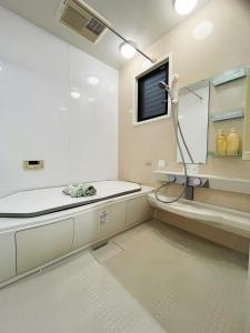 a bathroom with a shower and a sink and a tv at 子安居 Koyasui in Yokohama