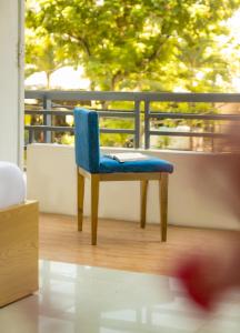 ダナンにあるHS Hotelのバルコニーに置かれた本が置かれた青い椅子