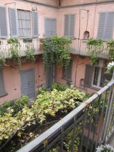 Charming and elegant apartment historic center of Milan في ميلانو: شرفة مع حفنة من النباتات أمام المبنى
