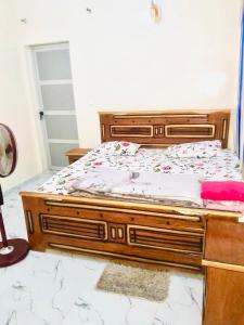 a bedroom with a wooden bed with flowers on it at Mame Thierno sene in Niakoul Rap