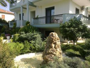 a house with a rock in the middle of a garden at Four Seasons Studio in Asprovalta