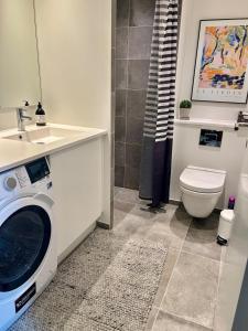 a bathroom with a washing machine and a sink at New copy apartment at Aarhus Ø in Aarhus +19 photos