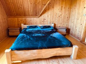 a bedroom with a bed in a wooden room at Apartamenty 1000m npm Murzasichle in Murzasichle