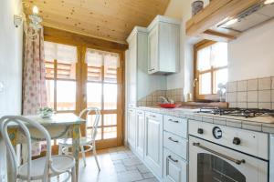 een keuken met witte kasten en een tafel en stoelen bij Casa Ursic Scrittore in Grimacco