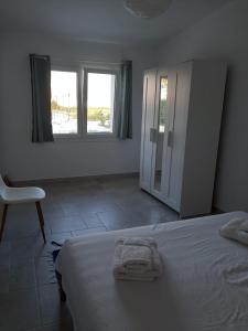 a bedroom with a bed and a chair and windows at Villa Lea in Pulsano