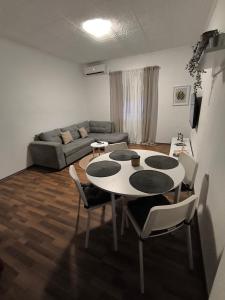 Una sala de estar con una mesa y sillas y un sofá. en Bocel, en Mali Lošinj