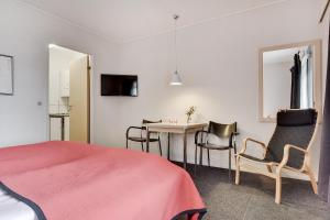 um quarto com uma cama, uma mesa e cadeiras em Hotel Varde em Varde