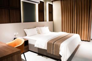 a hotel room with a bed and a desk and a desk at Jarzez Hotel Apartments Al Hail in Seeb +92 photos