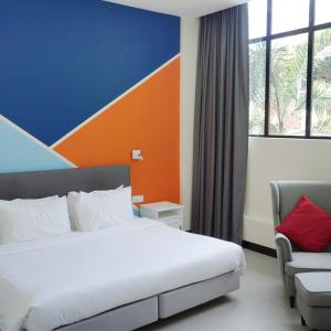 una habitación de hotel con una cama y una silla en Hollandse Club Resort, en Singapur