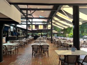 Un restaurante vacío con mesas y sillas y un buscador de mesas. en Hollandse Club Resort, en Singapur