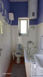 a bathroom with a toilet and a tub and a sink at Apartment Room with a view in Podgora