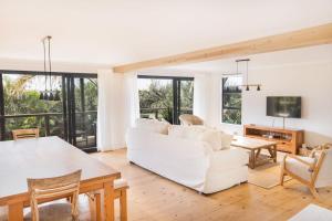 a living room with a white couch and a table at 10d Mimosa - The Spot - by African Perfection in Jeffreys Bay