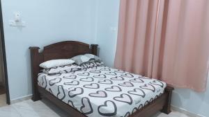 a bedroom with a bed with a wooden headboard and pillows at Homestay Singgah Tok Dir in Kuala Terengganu