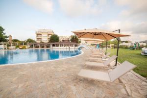 a row of chairs and an umbrella next to a pool at Arapya Sun Resort in Arapya