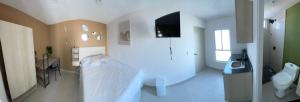 a large white room with a bed and a television at RC Studio loft san Jerónimo in Miravalle