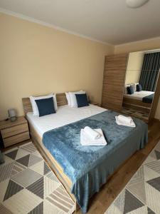 a bedroom with a large bed with two towels on it at South Beach Apartment at Valencia Gardens in Nesebar