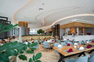 a rendering of a restaurant with tables and chairs at OceanView Alacarte Hạ Long in Ha Long