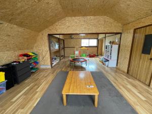 a living room with a wooden table and a kitchen at Yubari Hokkoriyado momijiyana in Yubari