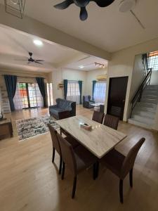 a living room with a wooden table and chairs at RZ Semi D Homestay in Kelebang Besar