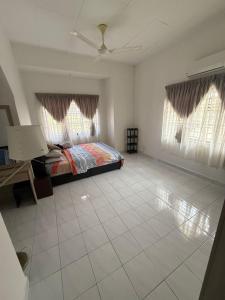 a bedroom with a bed and two windows at RZ Semi D Homestay in Kelebang Besar