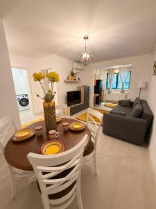 Una sala de estar con una mesa y sillas y un sofá. en Hils Pallady 9, en Bucarest