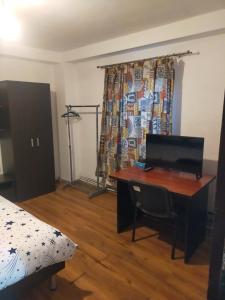 a bedroom with a desk with a computer on it at Casa Elena camere de Inchiriat in Bucharest +68 photos
