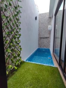 a swimming pool in the backyard of a house with green grass at Departamento Grace, moderno y centrico in Campeche