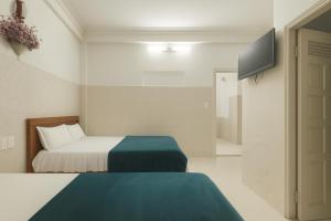a hotel room with a bed and a television at Viet Ha Hotel in Da Lat