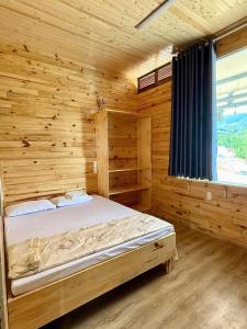 a bedroom with a bed in a wooden cabin at Aloha farm in Namban