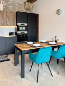 a kitchen with a wooden table and blue chairs at Historic waterfront factory house Royal William Yd in Plymouth
