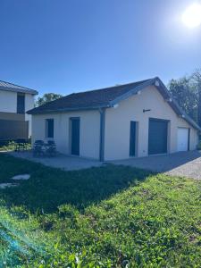 a white building with two garage doors in a yard at Maison indépendante avec terrasse in Fraroz