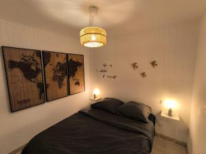 Un dormitorio con una cama con dos luces y pájaros en la pared. en Maison vendéene bord de mer - env 1 km plage-, en Saint-Vincent-sur-Jard