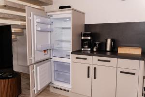 a white refrigerator with its doors open in a kitchen at Boutique Galerie im Herzen von Tauberbischofsheim in Tauberbischofsheim