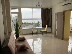 a living room with a couch and a table with chairs at Апартаменты Делюкс с 1 спальней in Dnipro