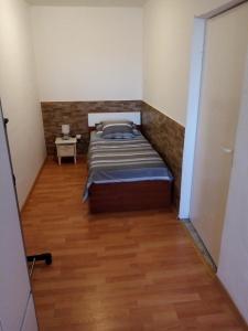 - une petite chambre avec un lit et du parquet dans l'établissement Apartment Buic, à Pula