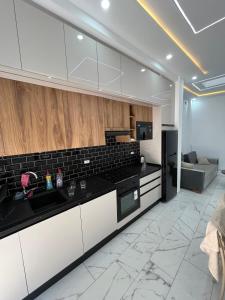 a kitchen with white cabinets and black counter tops at DjerbaArkouMidoun in Arkou