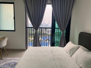 een slaapkamer met een bed en een groot raam bij Alinea BlueView Suites in Shah Alam