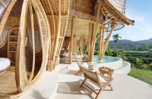 an outdoor patio with a large wooden building at Eden Villa by SARAYA Bali in Silebeng