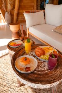 a coffee table with breakfast foods and drinks on it at Eden Villa by SARAYA Bali in Silebeng