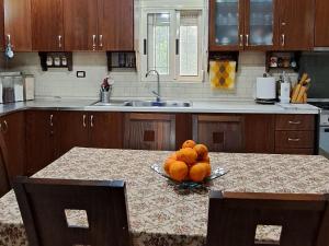 a kitchen with a bowl of oranges on a table at Kappa House Bed and Breakfast in Fier