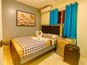 a small bedroom with a bed and a suitcase at Villa Rosa in San Felipe de Puerto Plata