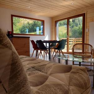 a bedroom with a table and chairs and a dining room at Chalet Les Noisetiers in Rochesson
