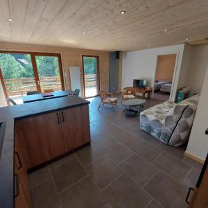 a large living room with a bed and a desk at Chalet Les Noisetiers in Rochesson