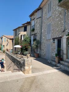 un hombre parado frente a un edificio de piedra en Villa la quietude, en Saint-Cézaire-sur-Siagne