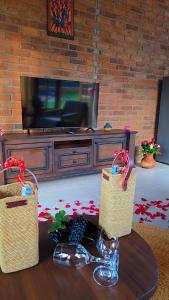 ein Wohnzimmer mit zwei Körben auf einem Tisch vor einem Fernseher in der Unterkunft Daima Escape in Usa River
