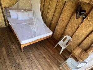 a bed and a plastic chair in a room at Villa Fria private beach cottage in San Vicente +26 photos