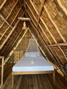 Una cama con colchón en una habitación con techo de paja en Villa Fria private beach cottage, en San Vicente