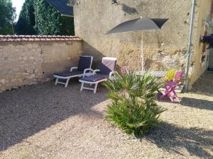 two chairs and a table with an umbrella in a yard at La Maisonnette de Gallerie in Cour-Cheverny